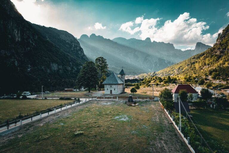 Scenic view of Theth village with mountains and historic church in Albania.